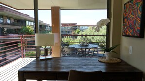 A balcony with a wooden table, chairs, and a potted plant. - Optimal Camelback, Scottsdale Luxury Condo Living All Year Round! (Scottsdale)