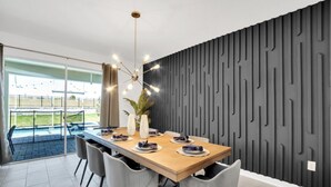 Un espace repas moderne avec une table en bois, des chaises grises et un mur noir à texture.