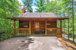 A rustic cabin with a wooden exterior, a front porch, and a welcoming sign. - Location! Private Log Cabin, Hot Tub, Fireplace (Pigeon Forge)