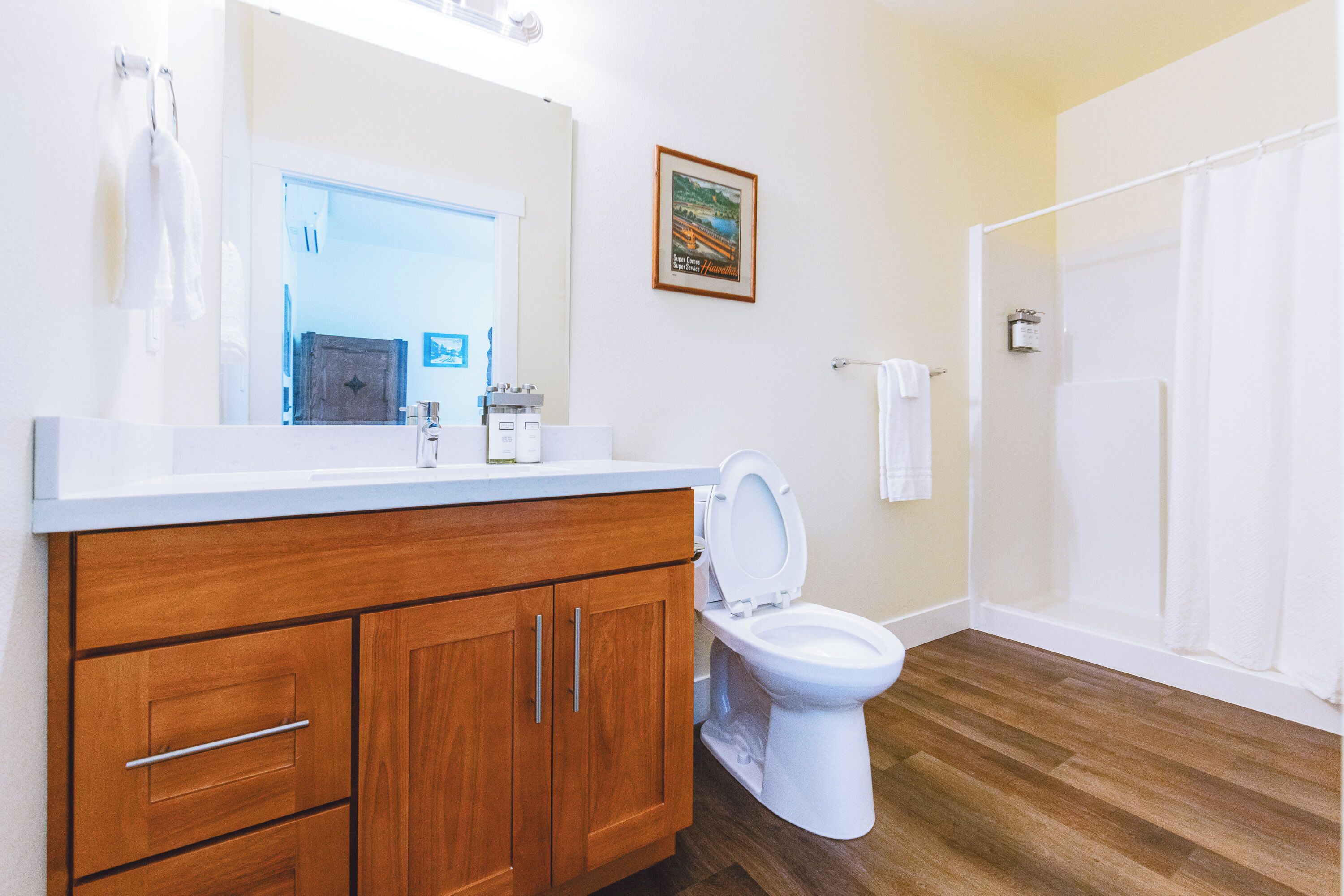 Een badkamer met een houten wastafelmeubel, een witte wasbak en een toilet.