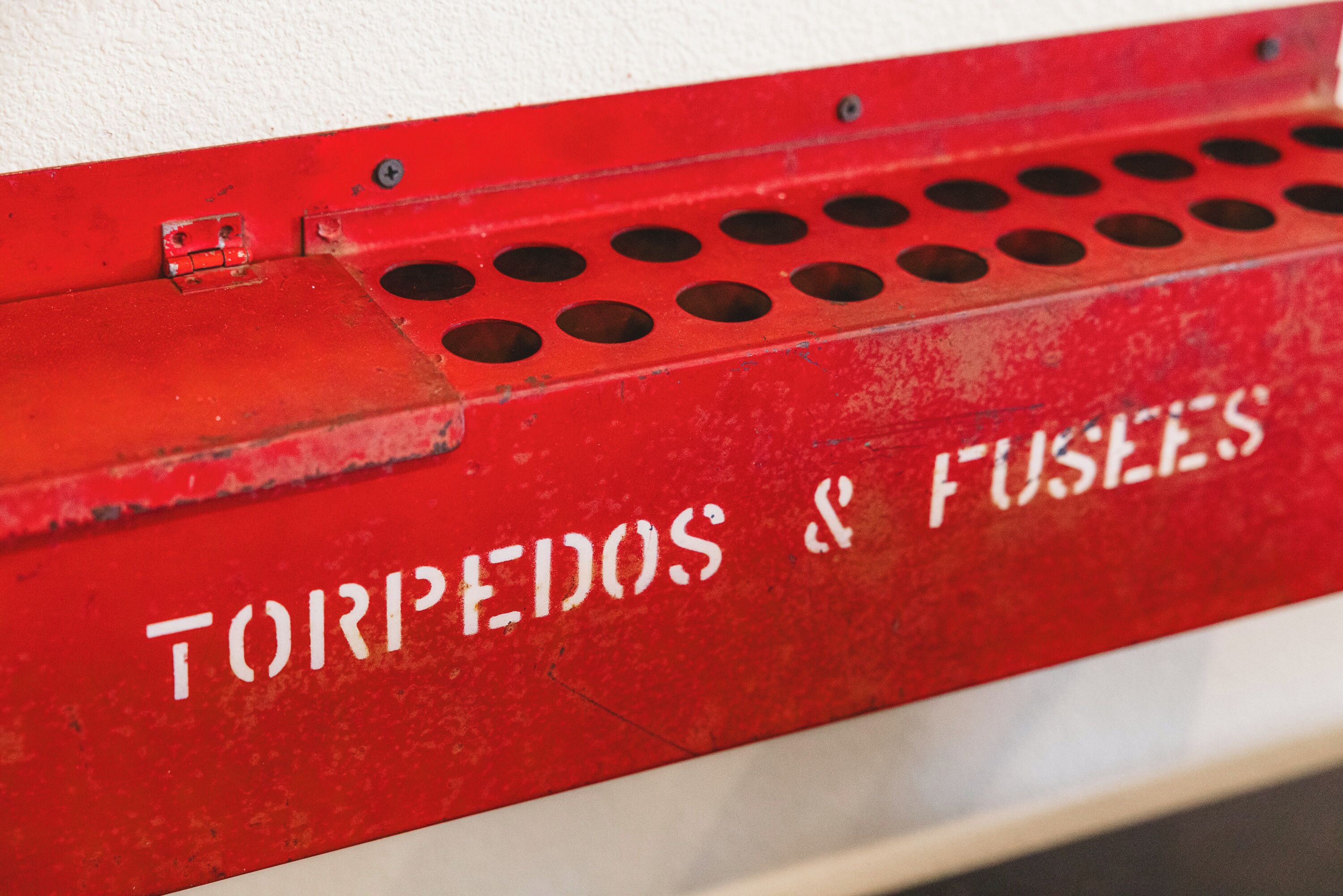 A red metal panel with the text "TORPEDOS & FUSEES" on it.