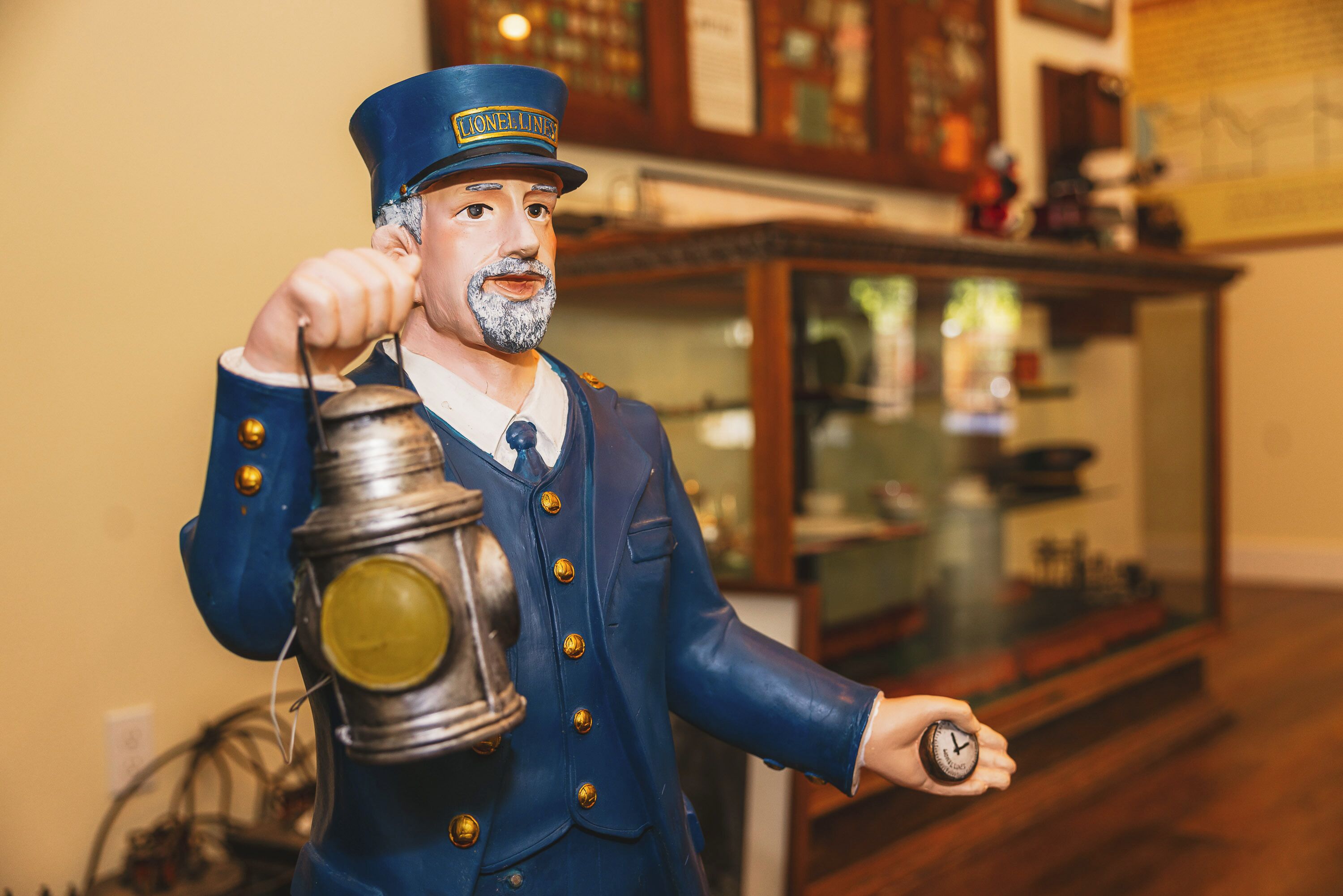 Una figurita de un jefe de tren sosteniendo un farol y un reloj.