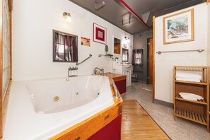 Ein modernes Badezimmer mit einer großen Badewanne, einem Holzbadezimmerflansch, einem Waschbecken und einem Spiegel.
