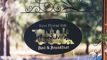 Naamplaatje voor Iron Horse Inn Bed & Breakfast, met een silhouet van een paard en bergen.