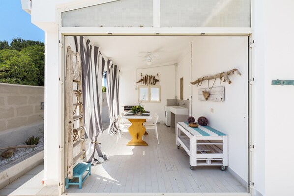A compact, well-lit room with a dining area, a small kitchen, and a seating area.
