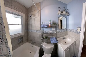 Ein Badezimmer mit Badewanne, Toilette, Waschbecken und Dusche.