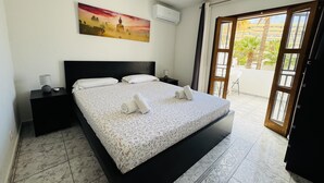 A bedroom with a bed, nightstands, a painting, and a view of the outside. - Town house for 4/6 people (Torviscas Bajo)