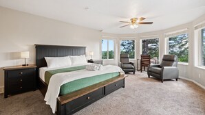 A bedroom with a bed, two chairs, a nightstand, a desk, and a ceiling fan. - Spacious Mountain Hideaway 4 BD 3 BA W/ Hot Tub (Ogden)