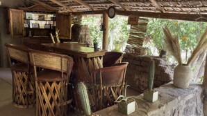 A rustic outdoor seating area with wooden furniture and cacti. - Hacienda Ramona (Comondu)