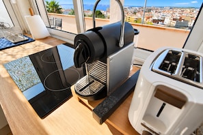 A kitchen with a coffee maker, toaster, and a tablet on a wooden countertop.