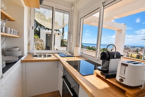 A modern kitchen with a view of a bridge and cityscape.