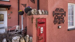 A red post office with a sign reading "Eye Olde Exeter Stores and Post Office." - The Old Post Office, Exford (Exford)