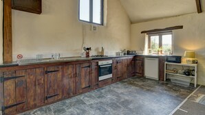 Une cuisine avec des meubles en bois, un four à micro-ondes et un évier.