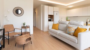 A modern living room with a sofa, two wicker chairs, a small table, and a mirror on the wall. - Vivelorural Agaete great garden & pool (Agaete)