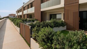 A modern multi-story residential building with balconies, a covered outdoor area, and a pathway. - Vivelorural Agaete great garden & pool (Agaete)