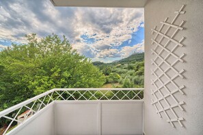 A balcony with a view of a green landscape and a lattice structure on the wall. - A 2 spacious apt w big balcony,4 min walk to beach (Split)