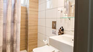 A modern bathroom with a toilet, sink, and shower area.