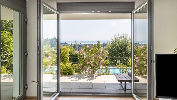 A balcony with a pool, a table, and a view of the landscape. - Apartment 'Am Lichtenberg' with Lake View, Private Terrace and Wi-Fi (Daisendorf)