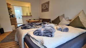 Un dormitorio con cama, almohadas, una mesita de noche, un espejo y vistas al comedor.