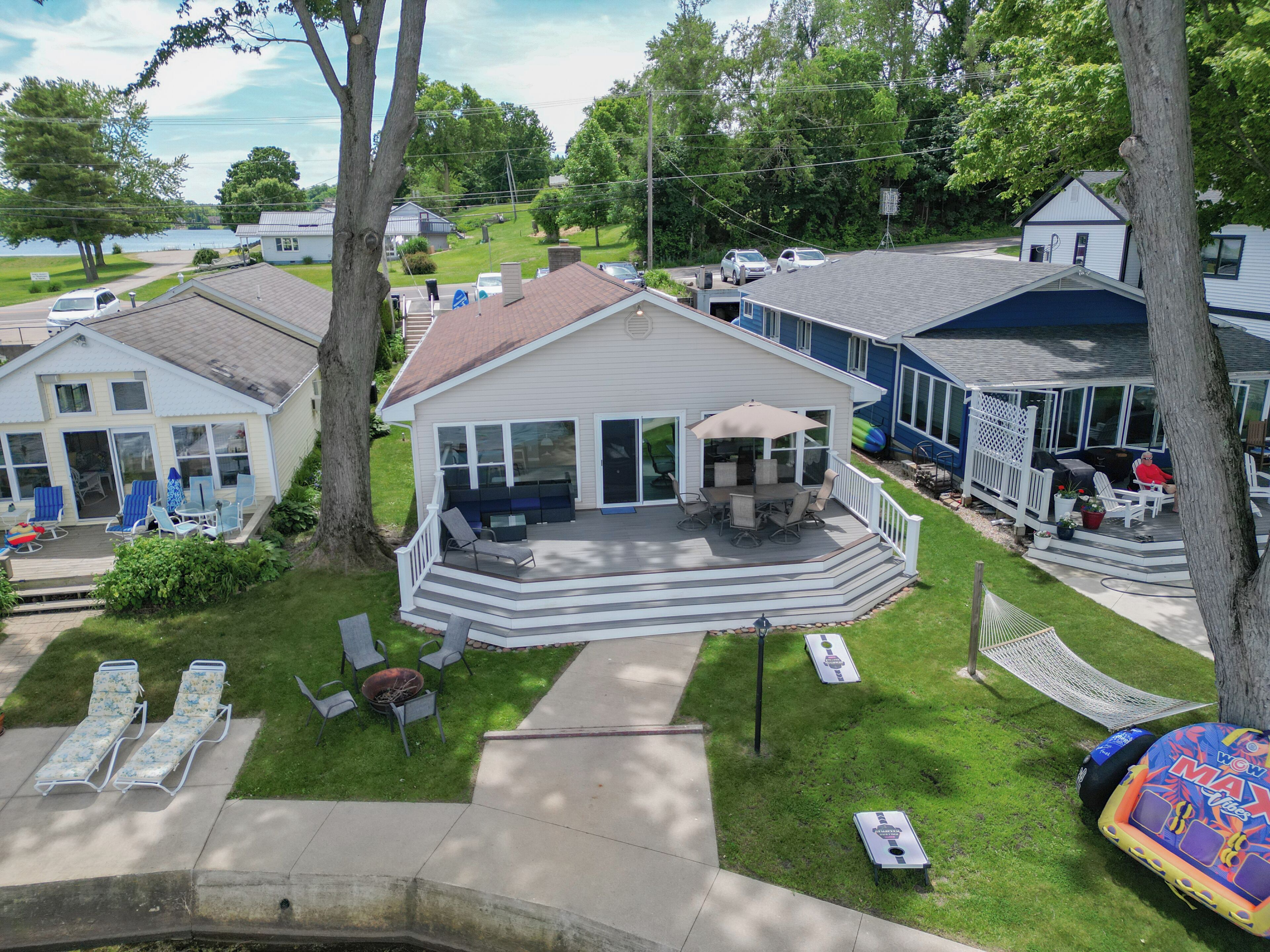 A residential property with a covered patio, outdoor seating, and a view of a lake.