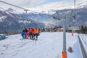 A ski lift with skiers in colorful winter gear. - Studio La Borracina Mountain View, Sauze d'Oulx, Italy (Sauze d'Oulx)