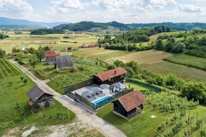 Una propiedad rural con piscina, viñedo y varias construcciones.