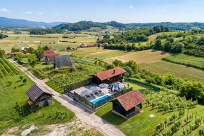Ein Wohngebiet mit mehreren Häusern, einem Schwimmbad und Weinbergen.