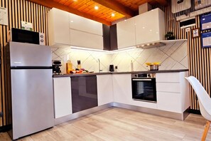 Eine moderne Küche mit Einbauofen, Kühlschrank und Geschirrspüler.