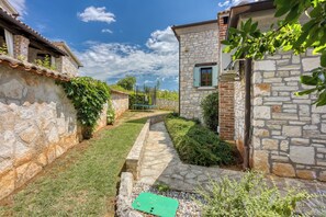 Stroll through the serene courtyard, surrounded by lush greenery and a traditional tiled roof.