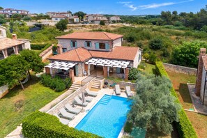 A villa with a swimming pool, outdoor seating, and a view of the surrounding landscape. - Rustic Pool Villa Aryana, Sveti Lovreč, Croatia (Sveti Lovreč)