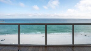 A beach view from a balcony with a railing, ocean, and a pier in the distance. - Beautiful 5 Star Condo right on the Beach!  Breathtaking Views!! (Navarre Beach)