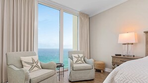 A hotel room with two armchairs, a small table, a lamp, and a bed. - Beautiful 5 Star Condo right on the Beach!  Breathtaking Views!! (Navarre Beach)