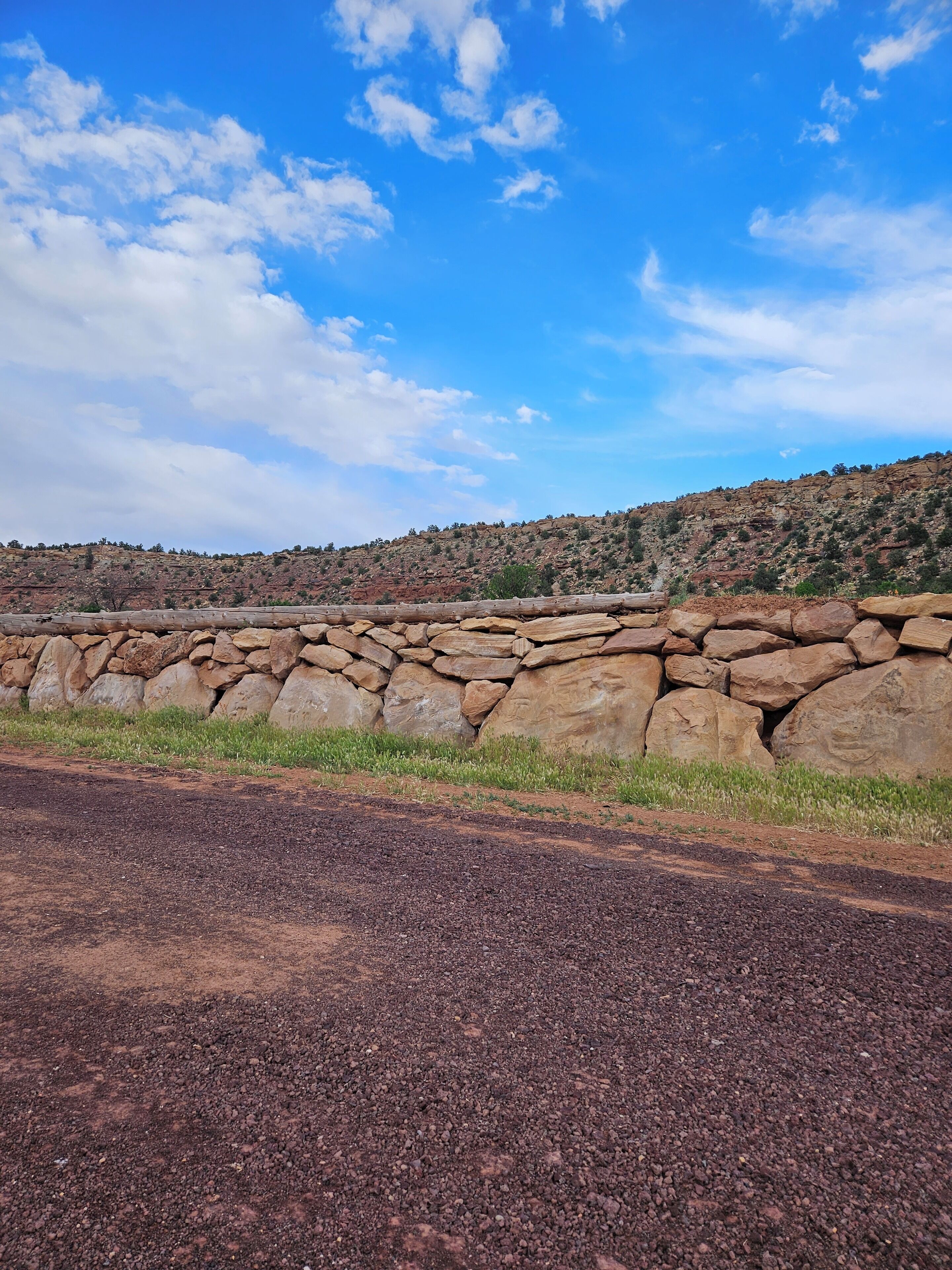 A rocky landscape with a stone wall and a clear blue sky.