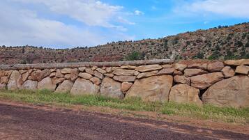 A rocky landscape with a stone wall and a clear blue sky.