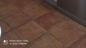 Una cocina con armarios de madera, lavavajillas y una encimera con microondas.