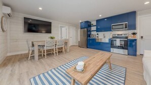 Une cuisine moderne avec des meubles bleus, un réfrigérateur en acier inoxydable et un four à micro-ondes.