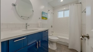 Une salle de bain avec un meuble-lavabo à deux vasques, des toilettes et une baignoire.