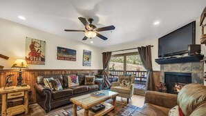 A cozy living room with a fireplace, leather sofas, a coffee table, and a TV. - 1BR Ski in Ski Out Steps to Lifts (Park City)