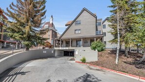 A building with a modern architectural style, featuring a prominent entrance and a parking area. - 1BR Ski in Ski Out Steps to Lifts (Park City)