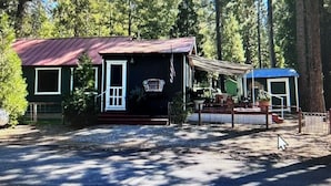 A cabin with a red roof, a porch, and a fenced yard. - 2 bedroom cabin in mineral (Mineral)