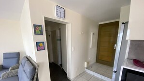 Una habitación con un sofá, un reloj y una puerta que da a otra estancia.