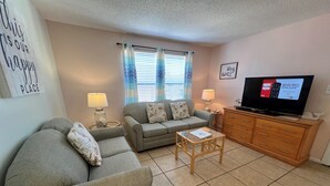 A living room with a sofa, a coffee table, a TV, and a cabinet.