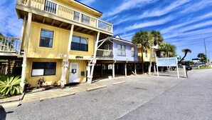 A two-story building with a balcony, a sign for Paradise Isle Resort, and a small office.