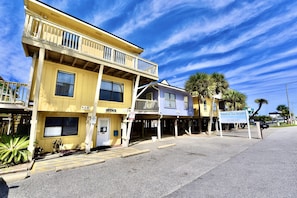 Un bâtiment à deux étages doté d’un balcon, d’une enseigne indiquant « Paradise Isle Resort », et d’un petit bureau.