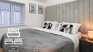 A bedroom with a queen-sized bed, a headboard, and a bedside table with a lamp. - NH - F3 · Nottage House Premier Apartments (Cardiff)