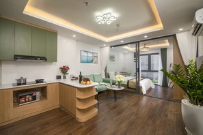 A modern kitchen with a built-in microwave, a green cabinet, and a dining area with a table and chairs.