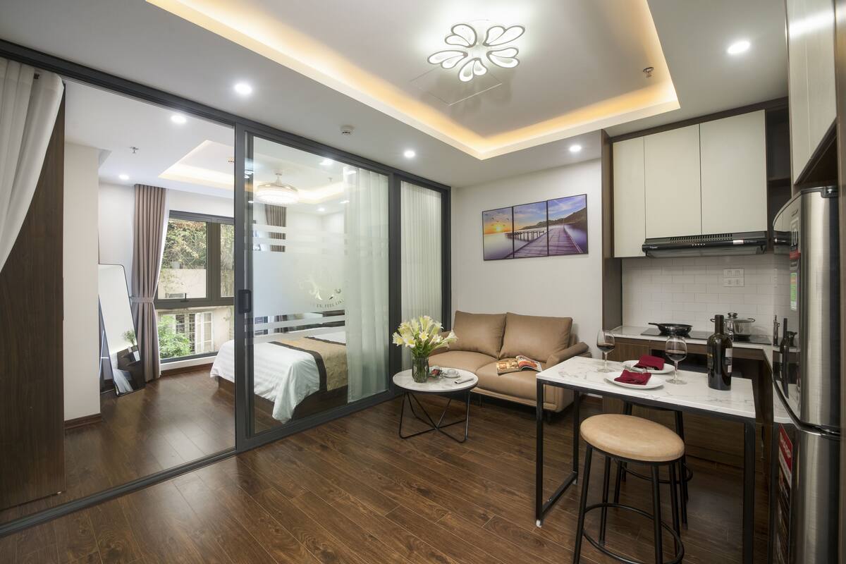 Cocina moderna con comedor, sofá y vistas al exterior.
