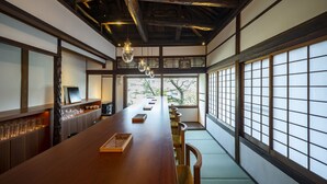 A traditional Japanese-style room with tatami flooring, a long wooden table, and sliding doors. - Shisekiryokan Kagetsu Taisyokan (Takeo)