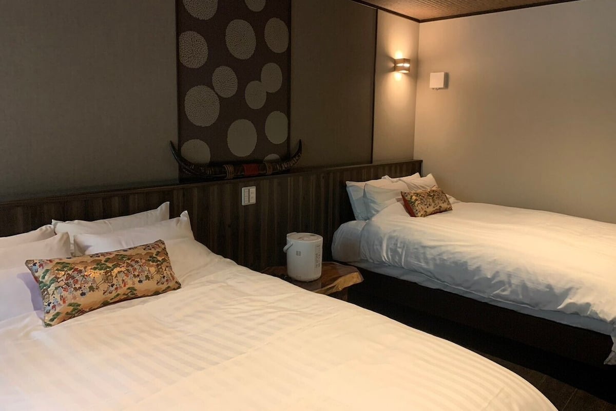 Ein Hotelzimmer mit zwei Betten, einem Wandheizkörper und einer Wanddekoration.