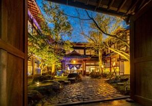 A traditional Japanese garden with a stone pathway, lanterns, and a wooden building. - Shisekiryokan Kagetsu Taisyokan (Takeo)